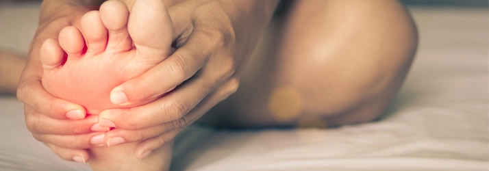 A person holding their foot in pain.